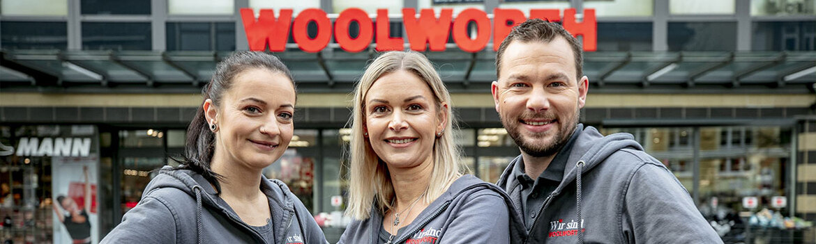 Drei MitarbeiterInnen stehen vor Woolworth Kaufhaus